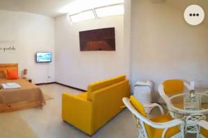 un soggiorno con un divano giallo e un tavolo di Apartamento Xandinha Amwilla Guesthouse a Mindelo