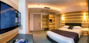 um quarto de hotel com uma cama e uma televisão de ecrã plano em Hotel Garden em Peschiera del Garda