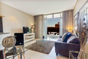 a living room with a couch and a tv at Harbouredge Suites in Cape Town