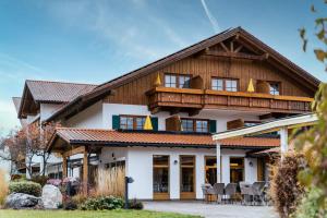 a large wooden house with a balcony at Hotel Sommer - Urlaubs- und Wellnesshotel in Füssen
