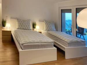 two beds in a bedroom with a balcony at Apartment Toelleturm - 45m2 - Single Beds - Wuppertal in Wuppertal