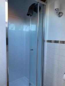 een douche met een glazen deur in een badkamer bij The Hayloft Cottage in Whitby +24 foto's