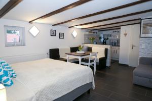 a bedroom with a bed and a table and a kitchen at Schlossweg-Apartment in Blankenburg