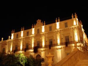 un bâtiment avec des lumières allumées la nuit dans l'établissement Landolina Palace Hotel, à Noto