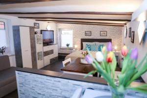 a living room with a bed and a table with flowers at Schlossweg-Apartment in Blankenburg