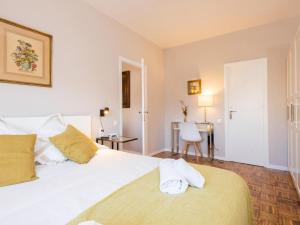 una camera da letto con un grande letto bianco con cuscini gialli di Clot market a Barcellona