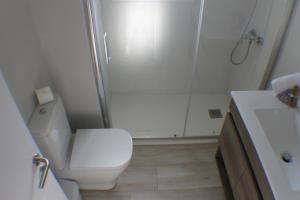 a bathroom with a white toilet and a shower at Agi Montseny in Roses