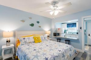 a bedroom with a bed and a ceiling fan at Upham Beach Inn in St. Pete Beach