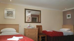 a hotel room with two beds and a mirror at Westholme Hotel in Blackpool