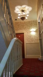 a hallway with a staircase and a ceiling fan at Westholme Hotel in Blackpool