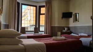 a hotel room with two beds and a window at Westholme Hotel in Blackpool