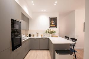 a kitchen with white cabinets and a white counter top at Stylish 2 Bedroom Apartment in the Heart of Madrid in Madrid