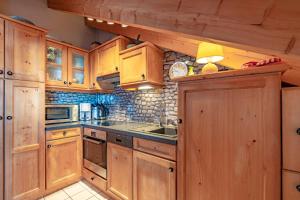 a large kitchen with wooden cabinets and a sink at Mein Lieblingsort in Burgberg