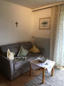 a living room with a couch and a cross on the wall at Haus Lechner Apartments in Sankt Jakob in Haus