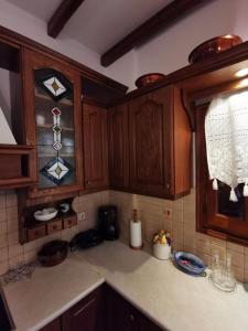 a kitchen with wooden cabinets and a counter top at Archontiko Elena in Volos +42 photos
