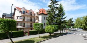 a large building with a tree in front of it at Pensjonat Kocius in Rewal