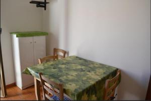 - une table à manger avec un tissu de table vert dans l'établissement Appartamento 17, à Ameglia