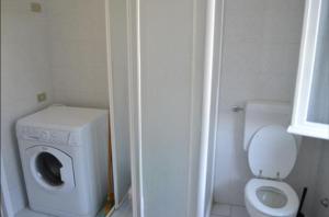 a small bathroom with a washing machine and a toilet at Appartamento 5 in Ameglia