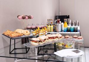 a buffet of sandwiches and pastries on a glass table at Melia Sitges in Sitges