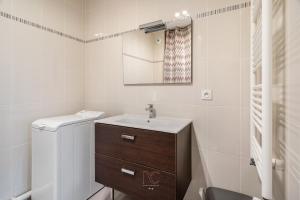 a white bathroom with a sink and a mirror at Disneyland-Paris 4 pers, Parking, Wifi, Netflix in Chessy