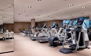 a gym with rows of treadmills and elliptical machines at Melia Sitges in Sitges