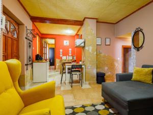 バラトンフェニヴェシュにあるKristóf Vendégházのリビングルーム(黄色のソファ付)、キッチンが備わります。