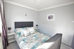 a bedroom with a large bed with a gray headboard at 1 Bedroom Holiday let in the Heart of West Wales in Carmarthen