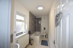 a bathroom with a tub and a toilet and a sink at 1 Bedroom Holiday let in the Heart of West Wales in Carmarthen