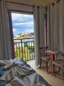 特里溫福的住宿－Pousada Solar Do Triunfo，一间卧室设有一张床和一个美景窗户。