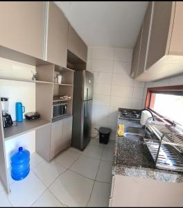 eine kleine Küche mit Spüle und Kühlschrank in der Unterkunft Flats family in Gravatá