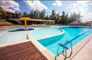 a large swimming pool with a yellow umbrella at Flats family in Gravatá