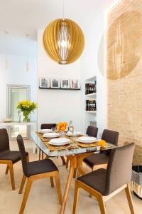 塞維利亞的住宿－Genteel Home Santa Teresa，一间带木桌和椅子的用餐室