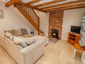 a living room with a couch and a fireplace at Belvedere in Cinderford