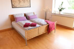 a wicker couch with pillows on it in a room at Gutenberg - helle und geräumige Wohnung in Uninähe in Mainz