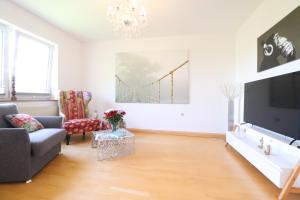 a living room with a couch and a tv at Gutenberg - helle und geräumige Wohnung in Uninähe in Mainz