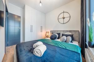 a bedroom with a large bed with towels on it at Plac Unii - Premium Apartments in Gdynia +45 photos