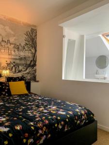 アンスニにあるLes Pénates de Loireのベッドルーム1室(壁に絵画が描かれたベッド1台付)