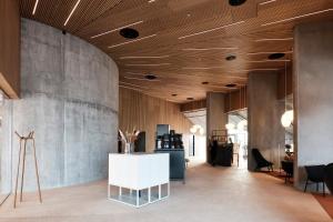 een lobby met houten plafonds en een tafel en stoelen bij A Place To Hotel Esbjerg in Esbjerg