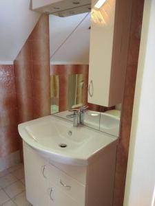 La salle de bains est pourvue d'un lavabo et d'un miroir. dans l'établissement Hanga Apartman, à Balatonlelle
