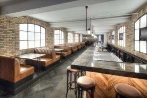 キッチナーにあるThe Walper Hotel, part of JdV by Hyattの茶色の革張りの座席とレンガの壁があるバー