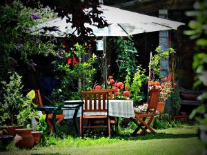 a table and chairs and an umbrella in a garden at Petit Garros in Fronsac