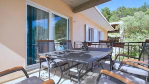 a black table and chairs on a balcony at Apartment Slatina Bay in Vela Luka