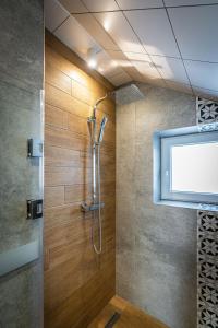 a shower in a bathroom with a glass door at Aparteo Apartament Pod Wierchem in Kościelisko