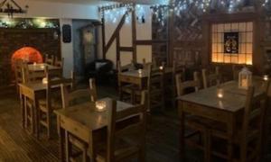 un restaurante con mesas y sillas en una habitación en The Cottage At The Retreat, en Leek