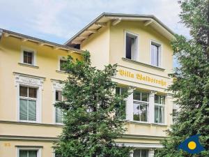 バンシンにあるFerienvilla Waldstraße Whg 07の黄色の看板が貼られた黄色い建物