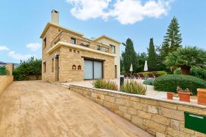 a stone house with a stone wall and a driveway at Villa Camelot by Ezoria Villas in Coral Bay