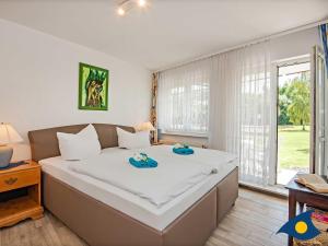 班辛海的住宿－Ostseepark 12 Whg 02，一间卧室配有一张大床和两条毛巾