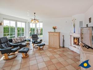 a living room with a couch and chairs and a fireplace at Haus Achterwasserblick in Ueckeritz