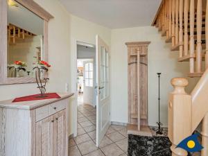 a kitchen with a staircase and a stair case at Haus Achterwasserblick in Ueckeritz +8 photos