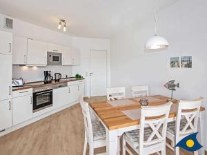 cocina y comedor con mesa de madera y sillas en Villa Hügel B 03 "Pirna", en Ahlbeck